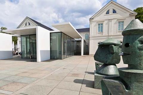 Blick auf das Gebäude des Max-Ernst-Museums. Im Vordergrund stehen zwei Skulpturen.