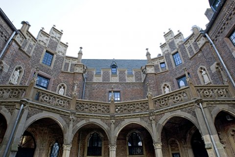 Ein Blick aus dem Innenhof auf die Fassade des Renaissanceschlosses mit Erkern, Fenstern und Relieffiguren.