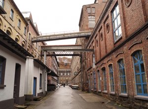 Ein Blick durch die schmale Tuchmacherstraße mit ihren historischen Fabrikgebäuden links und rechts.